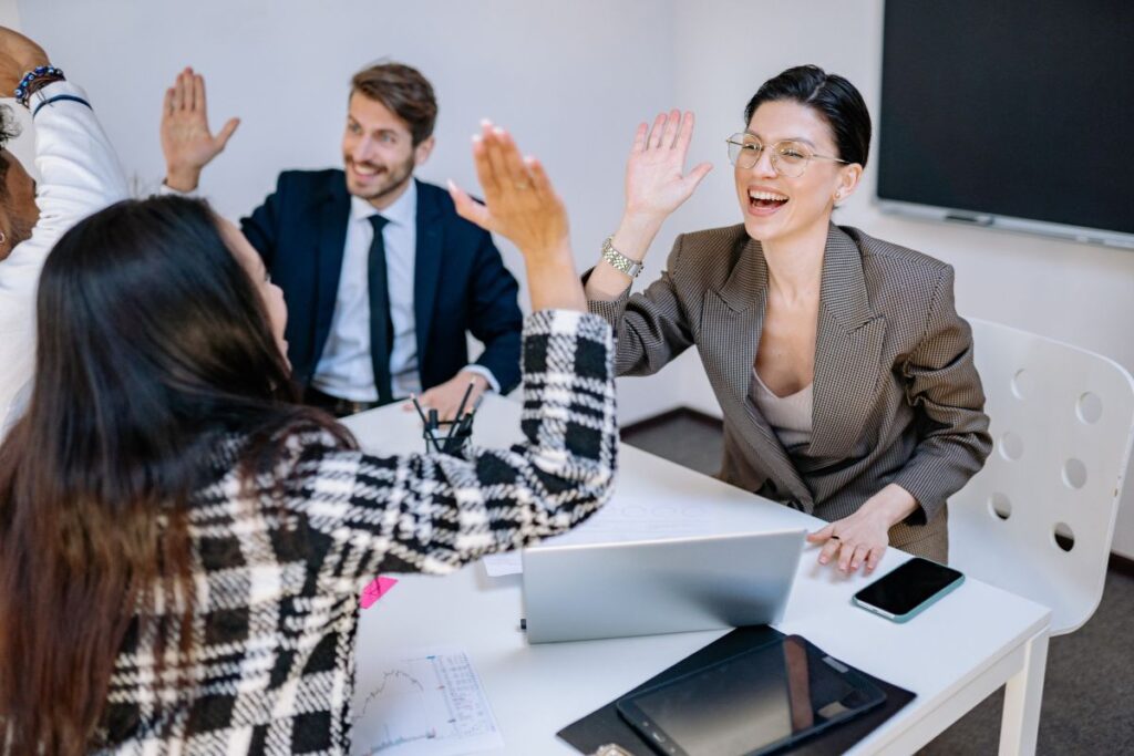 Two women high five during a meeting.