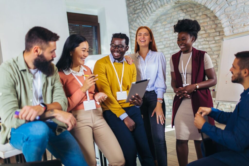 group of colleagues smile and laugh together at work