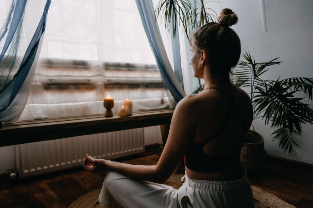 A woman meditates at home.