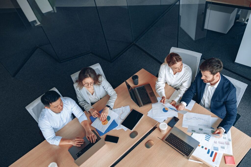 A group of office workers work on a project together in a meeting room. 