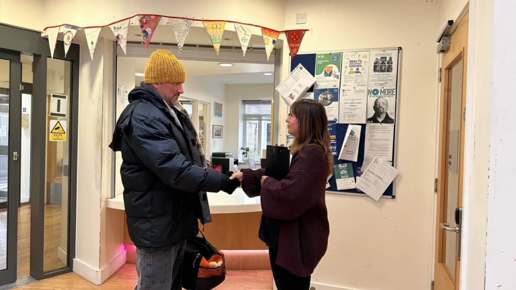 Alabaré employee shakes hands with one of the people they are helping. 