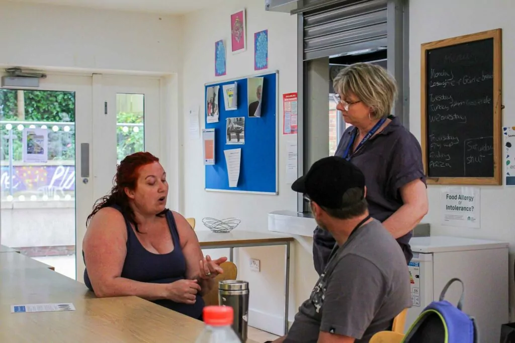 An Alabaré employee listens to two people they are offering support to