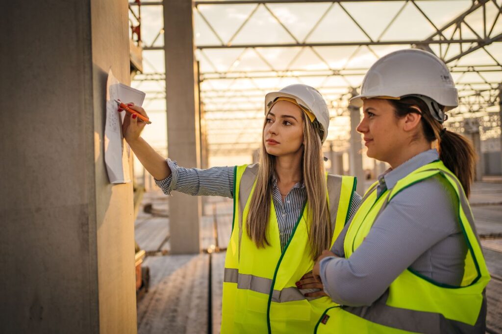 two women work on a construction site 