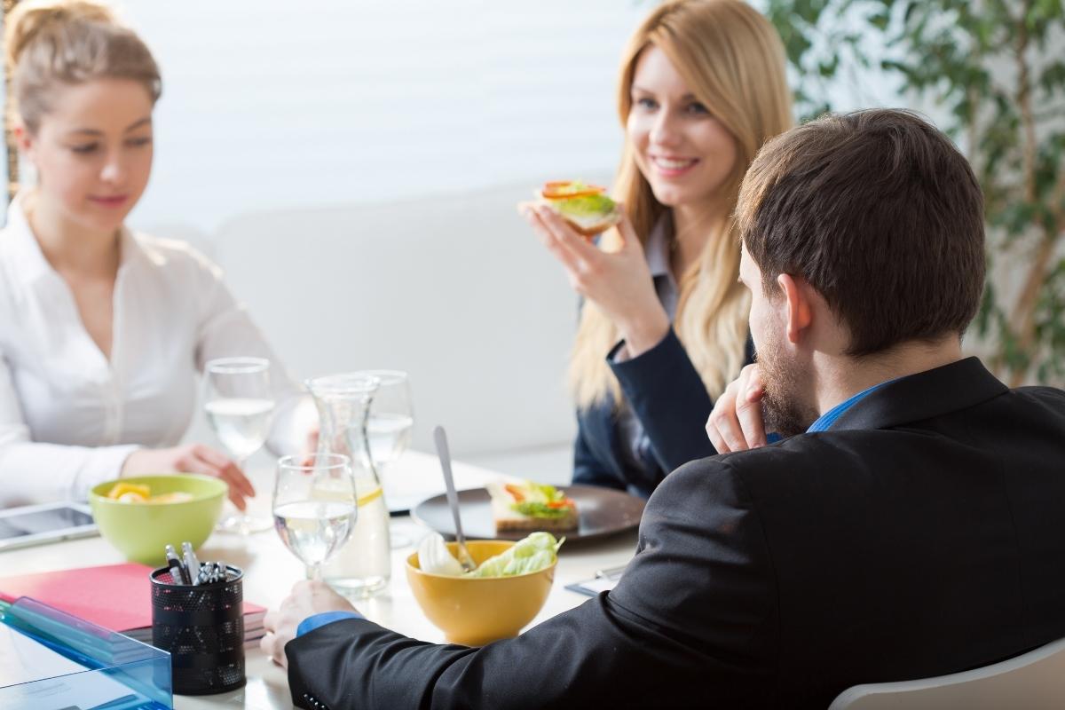 A group of coworkers sit together and eat healthy food