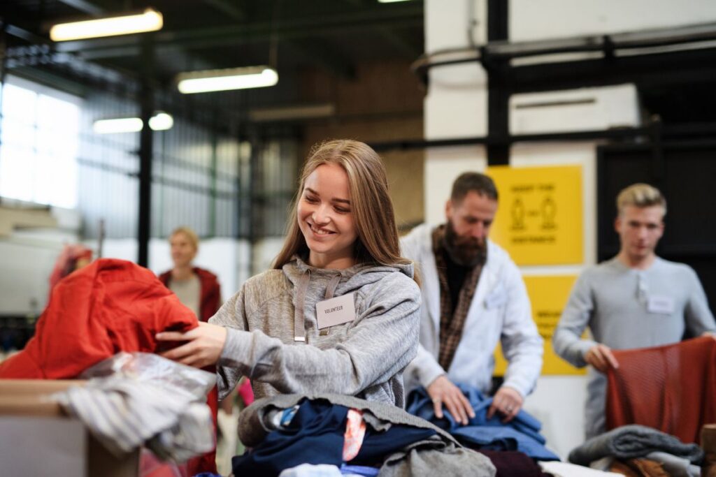 A female volunteer looks through clothes donations.