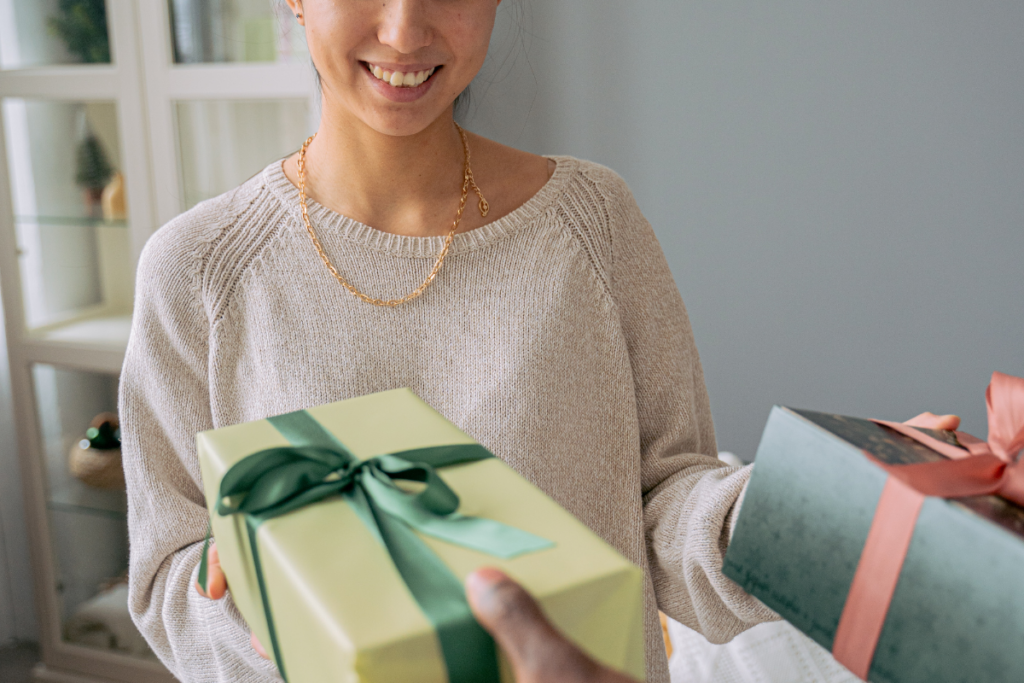 A woman receives and exchanges some gifts. She smiles.