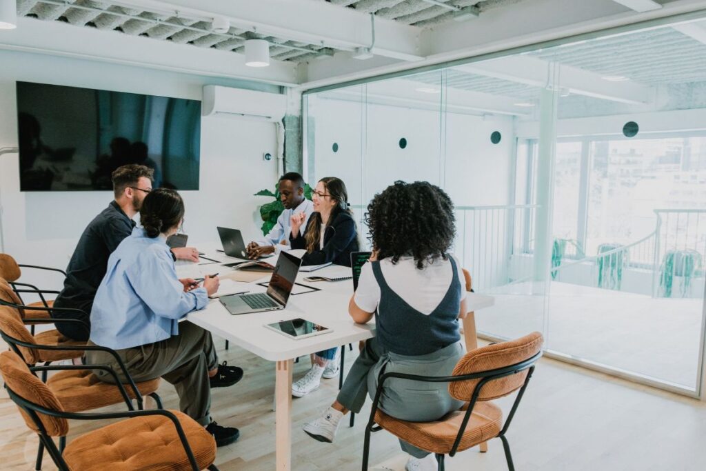 A team sit together and work on a project in a meeting room.