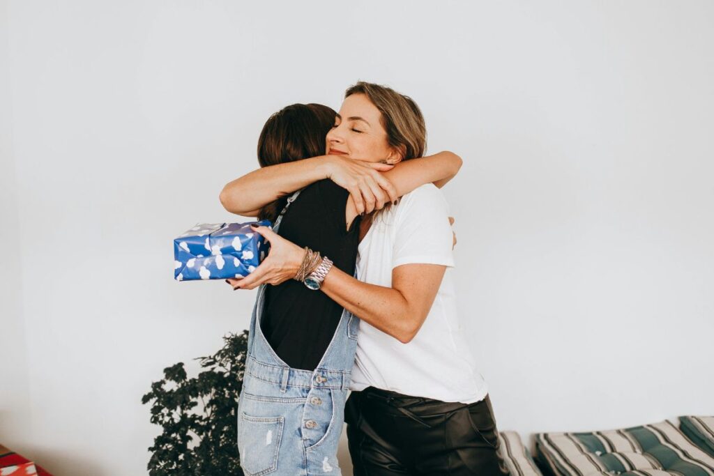 Two colleagues hug after exchanging gluten free gifts at work