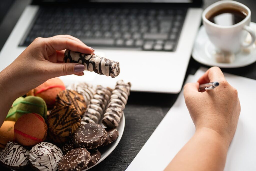 A woman enjoys vegan chocolates and a black coffee whilst at work.