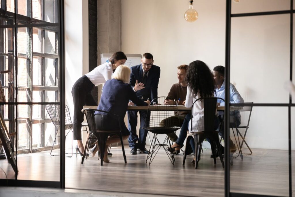 A group of professionals brainstorm together in a meeting.