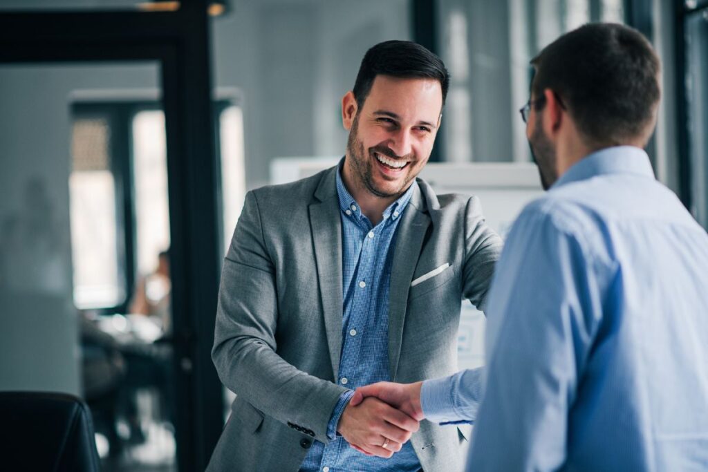 A man shakes hands with his candidate. They are both smiling.