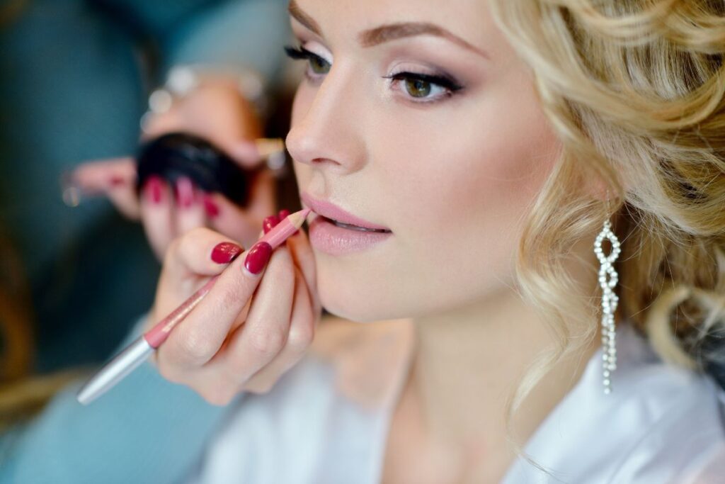 A woman gets her makeup done for her wedding.