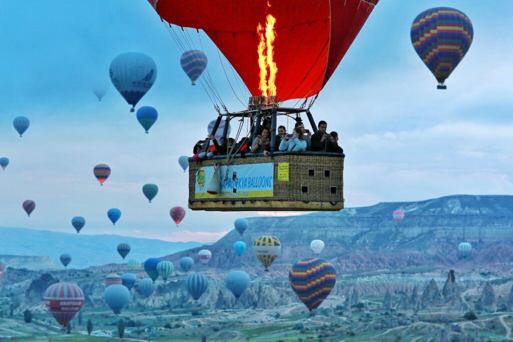 A group of tourists experience a hot air balloon ride. 
