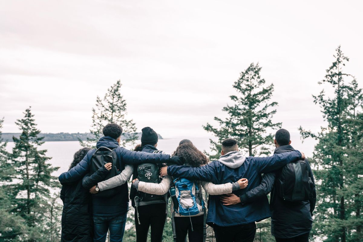 A group of sustainability volunteers stand together and look at the landscape