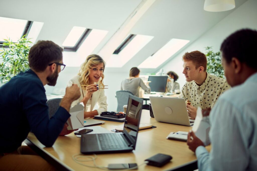 A group of employees eat together at work.