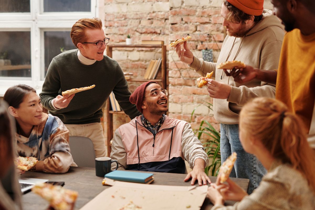 A group of employees enjoy vegan pizza together