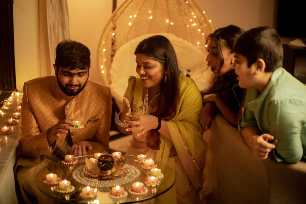 A group celebrate Diwali together by lighting candles.