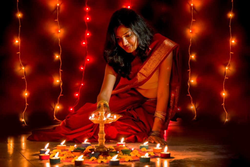 A woman lights candles as she celebrates a Diwali celebration