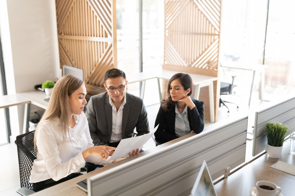 Three employees sit in a review together