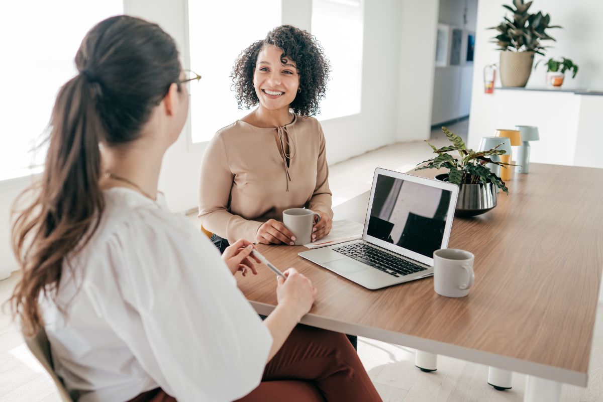 Two women sit in a year end review meeting