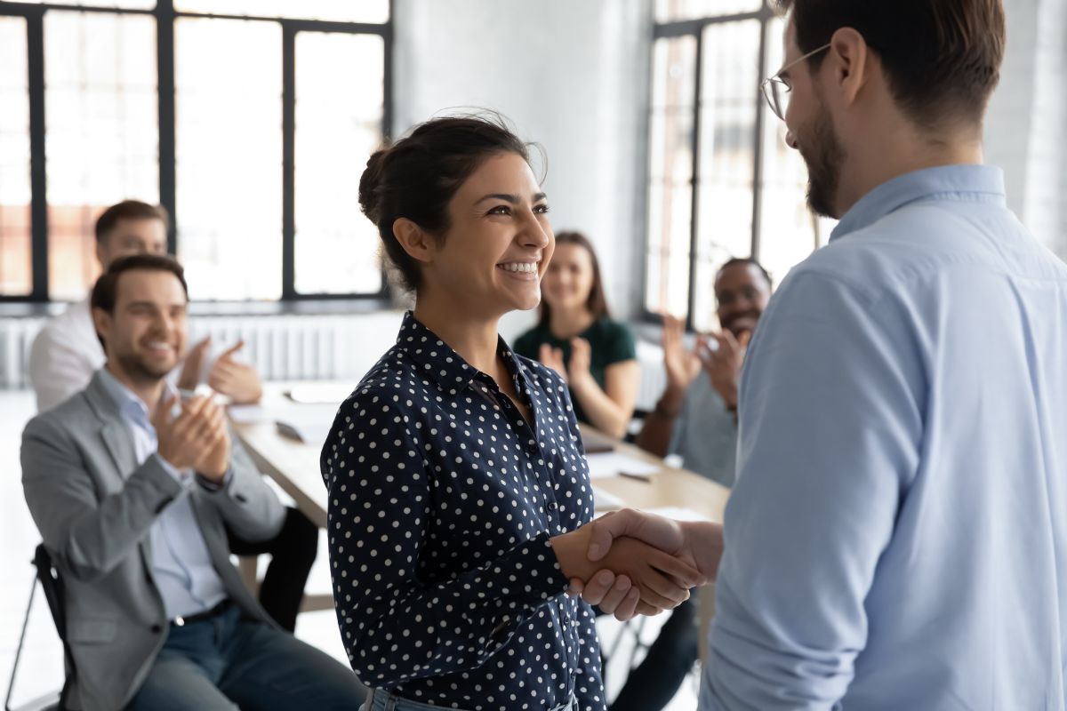 A female employee passes a corporate gift to her colleague