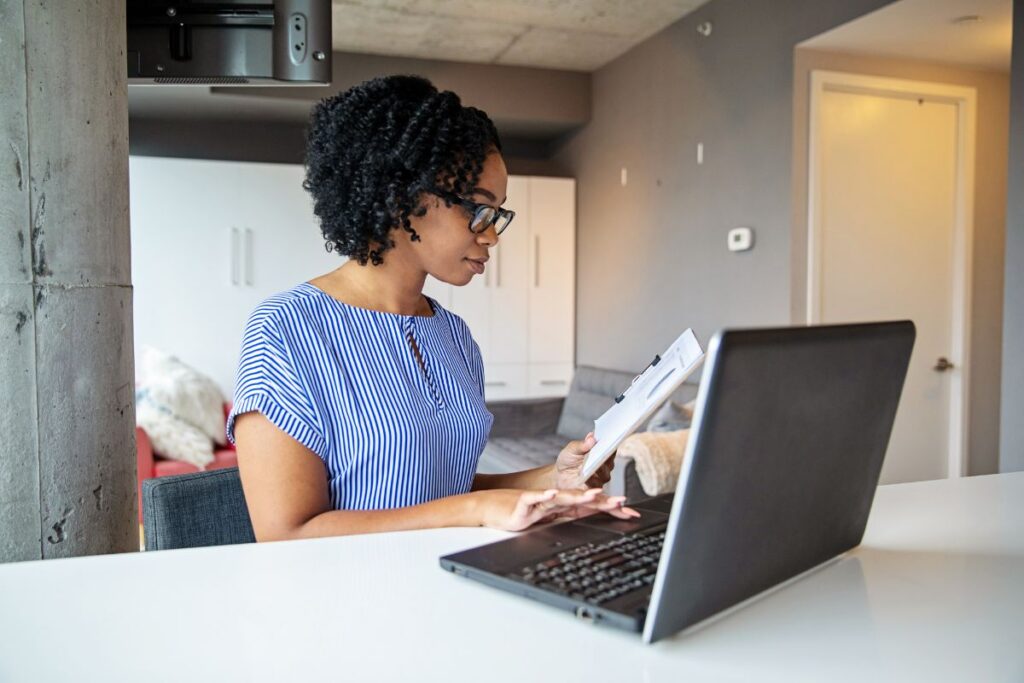A woman works on her financial budget as she works from home 