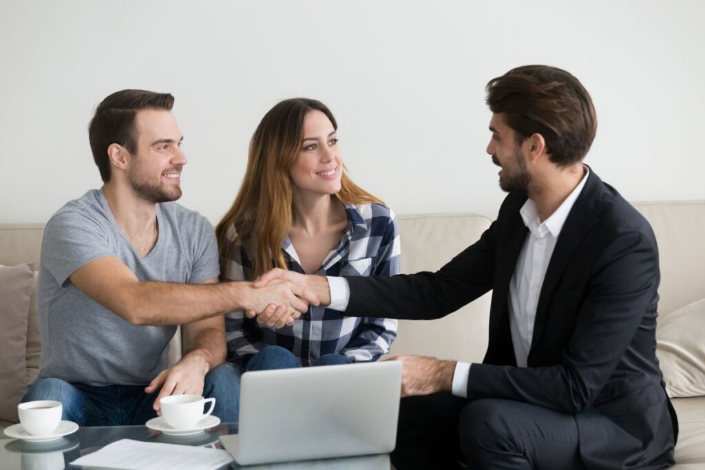 A couple shake hands with a letting agent 