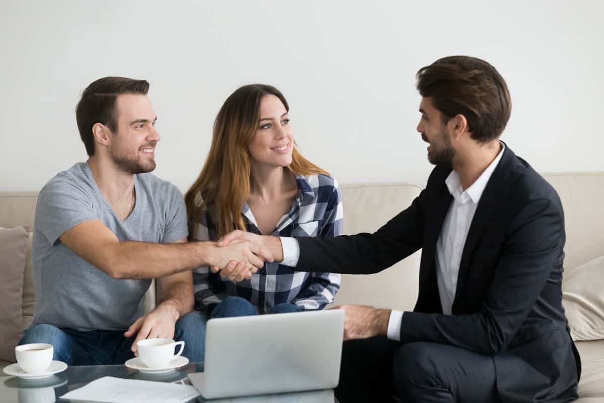 A couple shake hands with a letting agent