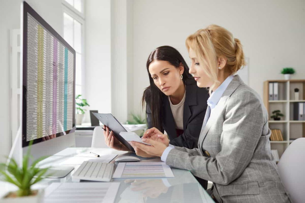 two female employees collab together in a meeting 