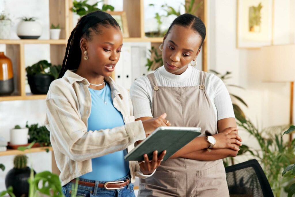 two female employees collaborate together in a meeting at a bcorp