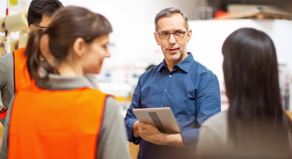 A man works with his team in a warehouse